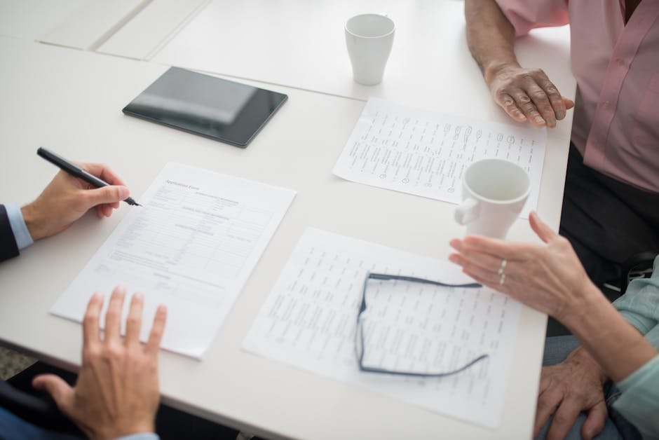 Physician at a desk reviewing a disability insurance policy with a financial advisor